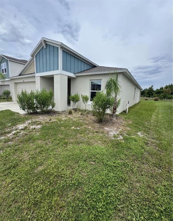 A single-story house with blue vertical siding, a garage, and a grassy front yard — 5480 SILTSTONE STREET, LAKELAND, FL