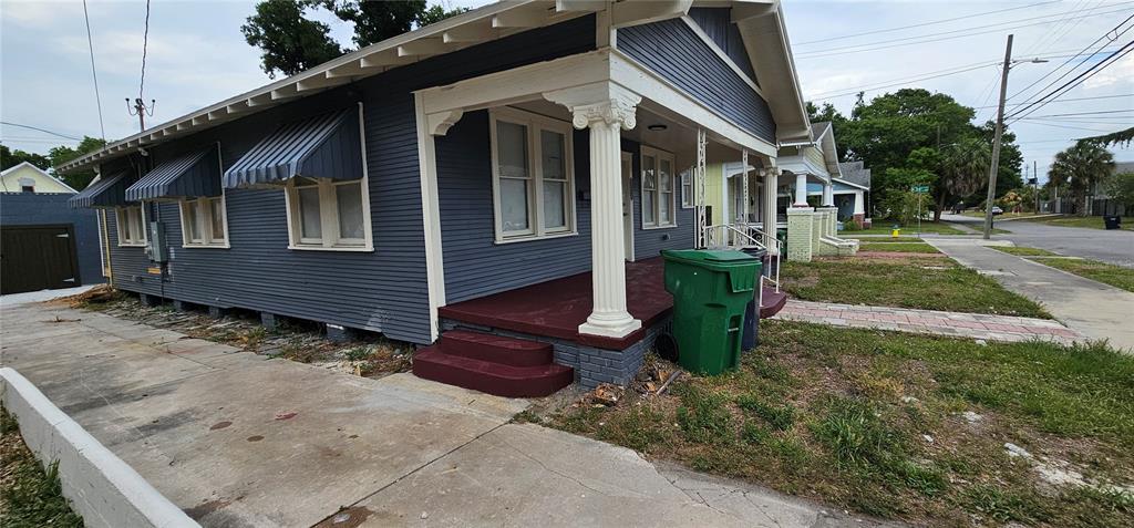 A blue house with a covered front porch and white columns sits along a street — 2312 E 8TH AVENUE, TAMPA, FL