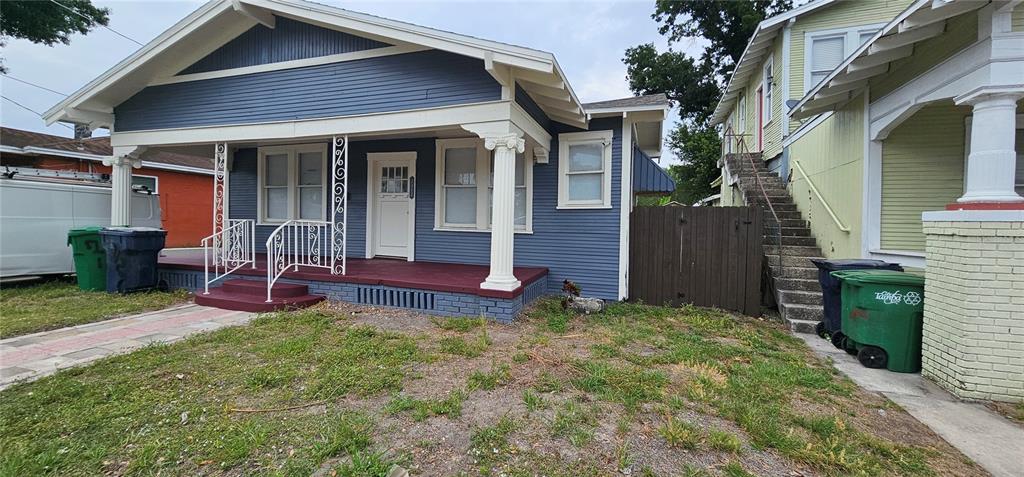 A blue bungalow with a front porch, white columns, and a staircase leading to an apartment — 2312 E 8TH AVENUE, TAMPA, FL