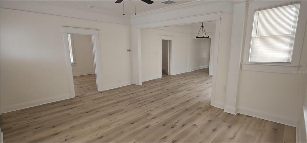 An interior view of a living area featuring light wood-look flooring and white walls — 2312 E 8TH AVENUE, TAMPA, FL
