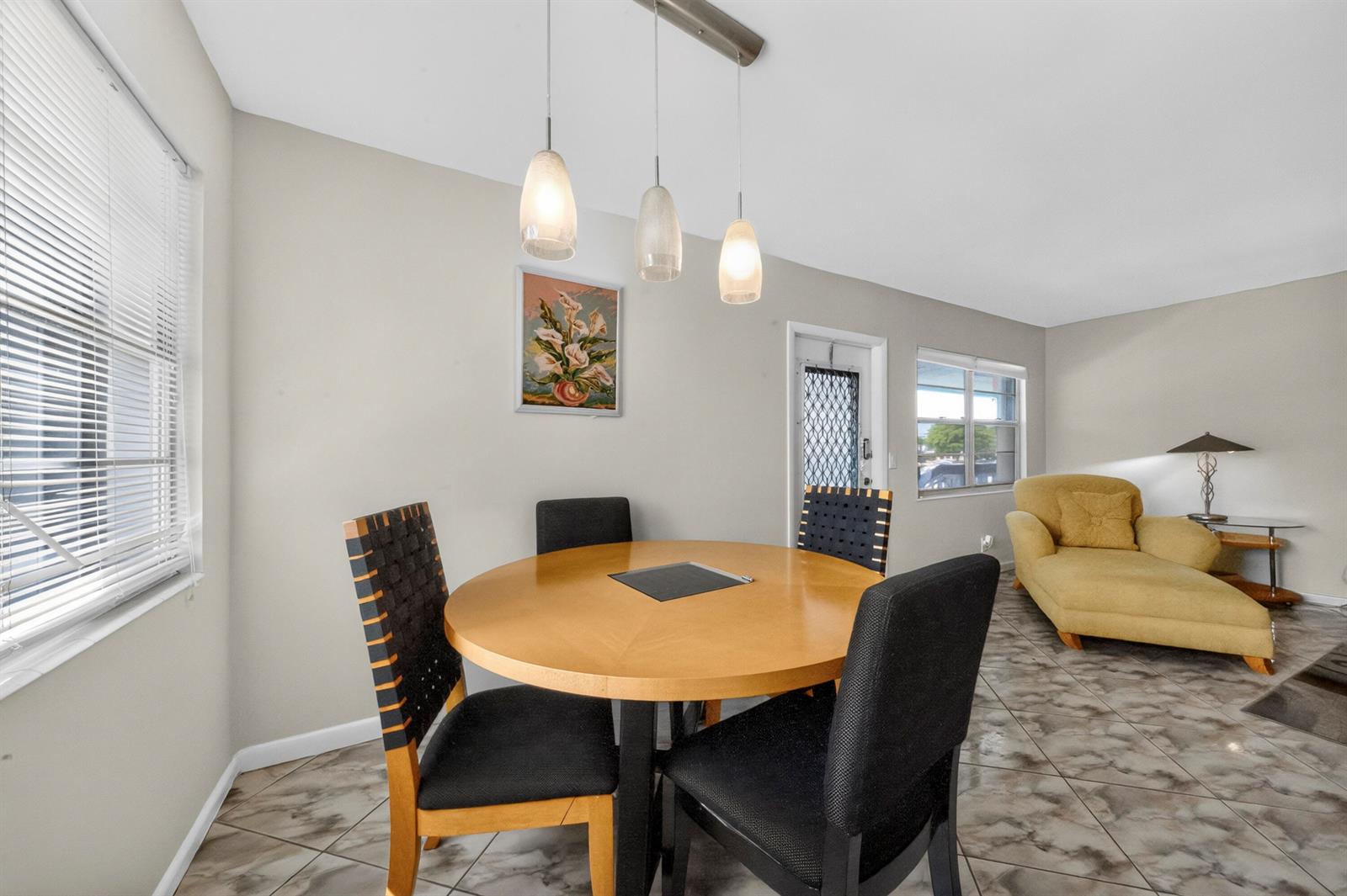 A dining area features a round wooden table, four chairs, and three pendant lights — 176 Upminster H # 176, Deerfield Beach FL 33442, DEERFIELD BEACH, FL