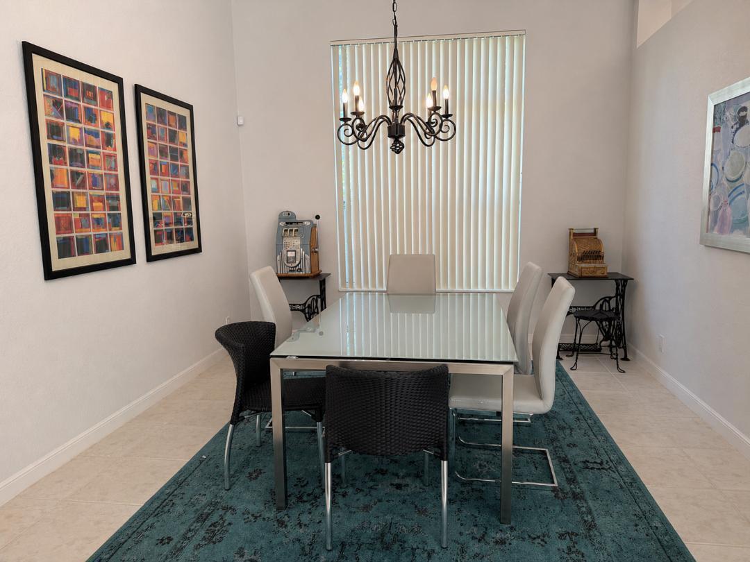 A dining room features a glass-topped table, six chairs, a chandelier, and a blue rug — 4285 NW 62nd Road, Boca Raton FL 33496, BOCA RATON, FL