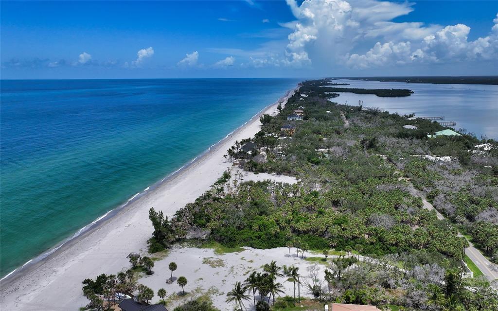 An aerial view shows a sandy beach bordering the ocean next to a wooded area — 6160 MANASOTA KEY ROAD, ENGLEWOOD, FL