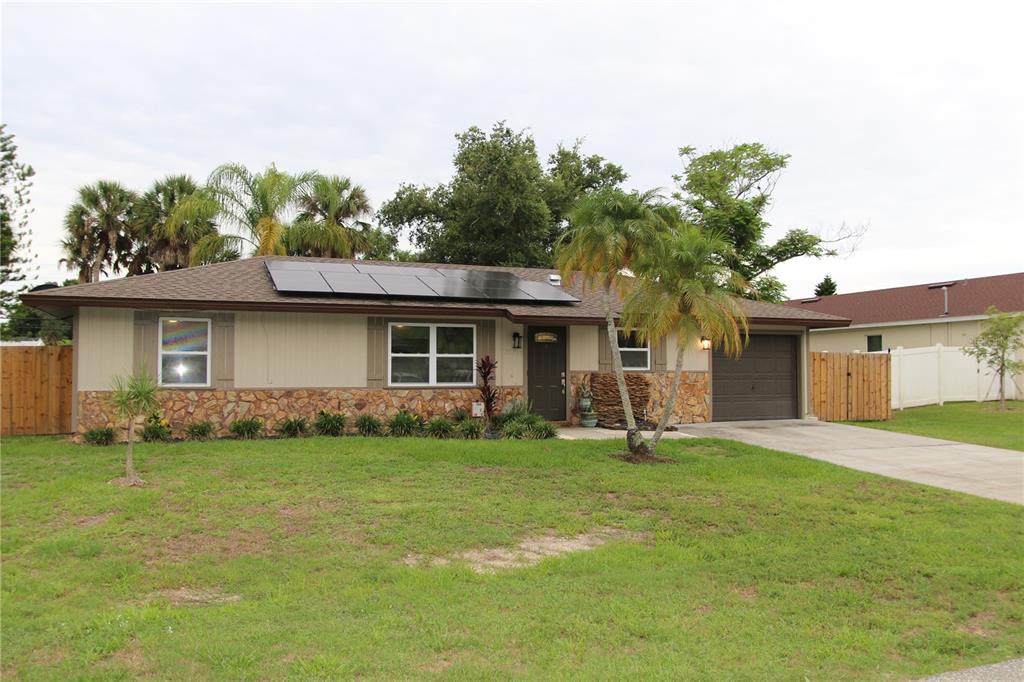 A single-story house with a stone facade, solar panels, and a front-facing garage — 20367 ANDOVER AVENUE, PORT CHARLOTTE, FL