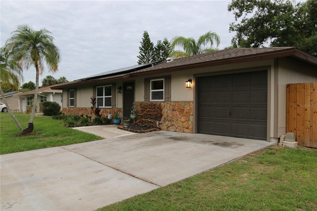 A single-story house with a concrete driveway, stone facade, and an attached garage — 20367 ANDOVER AVENUE, PORT CHARLOTTE, FL