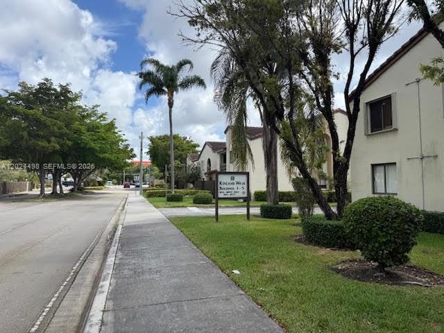 A sidewalk runs alongside a road leading to a residential complex with palm trees — 8911 SW 123rd Ct # 203, Miami FL 33186, MIAMI, FL