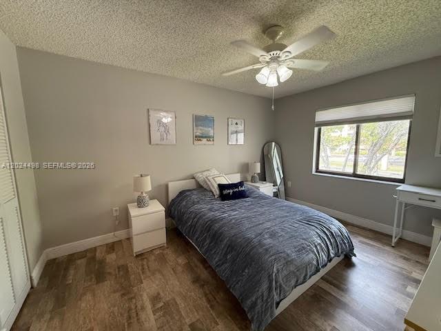 A bedroom features a bed with a blue comforter, a ceiling fan, and a window — 8911 SW 123rd Ct # 203, Miami FL 33186, MIAMI, FL