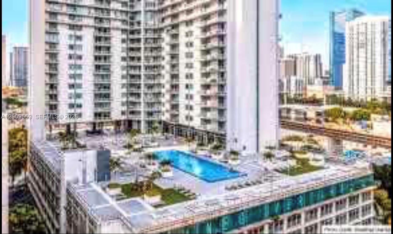 An elevated exterior view shows a high-rise building with a rooftop swimming pool and deck — 690 SW 1st Ct, Miami FL 33130, MIAMI, FL