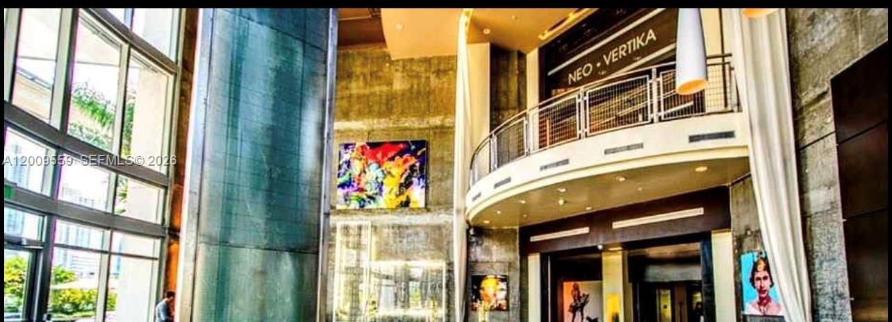 The lobby of Neo Vertika features high ceilings, concrete walls, modern art, and a curved balcony — 690 SW 1st Ct, Miami FL 33130, MIAMI, FL