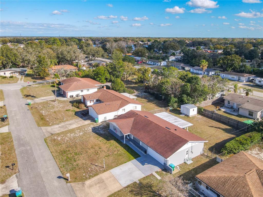 An aerial view shows several single-story suburban houses with brown roofs and driveways — 895 SUPERIOR STREET, DELTONA, FL