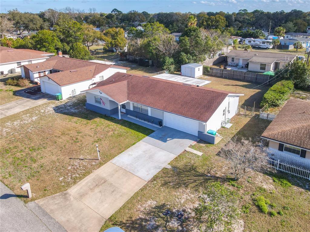 An aerial view shows a single-story house with a brown roof and a concrete driveway — 895 SUPERIOR STREET, DELTONA, FL