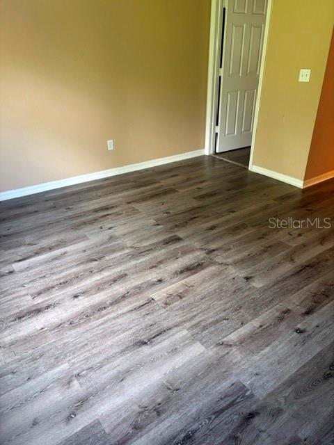 An empty room features light brown walls and gray wood-look laminate flooring — 2014 STONE ABBEY BOULEVARD, ORLANDO, FL
