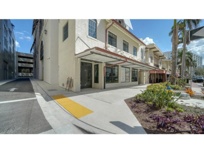 An exterior view of a multi-story building with a covered walkway and a yellow tactile strip — 33 S PALM AVENUE UNIT 904, SARASOTA, FL