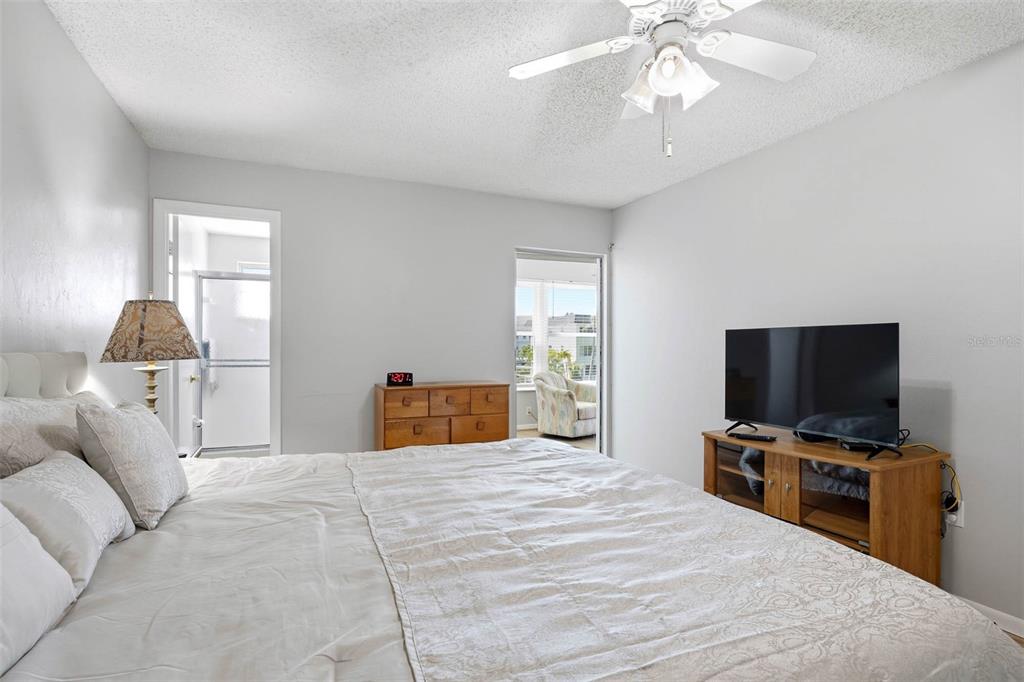 A bedroom features a bed, a television on a wooden stand, and a ceiling fan — 2850 59TH STREET S UNIT 215, GULFPORT, FL