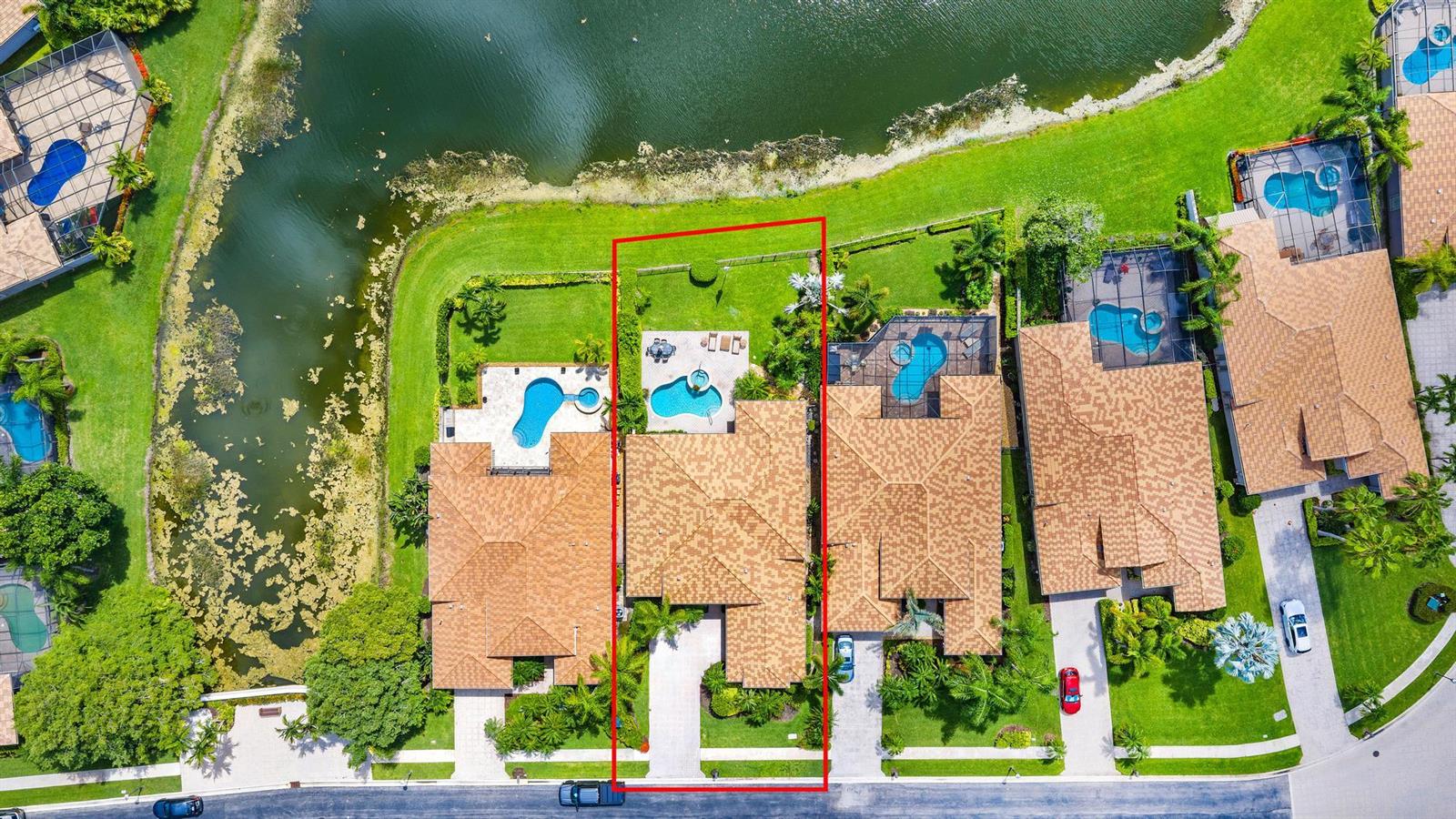 Aerial view of a residential property with a swimming pool and patio overlooking a lake — 7510 Blue Heron Way, West Palm Beach FL 33412, WEST PALM BEACH, FL