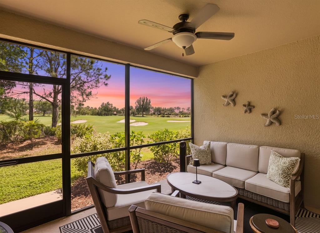 A screened-in patio features outdoor furniture, a ceiling fan, and a view of a golf course — 12720 SORRENTO WAY UNIT 101, BRADENTON, FL