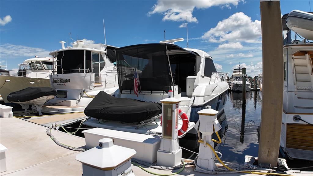 Several yachts are docked at a marina under a bright blue sky with clouds — 102 RIVIERA DUNES WAY UNIT S-46, PALMETTO, FL