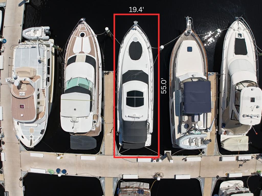 An aerial view shows a boat docked in a slip measuring 19.4 feet by 55 feet — 102 RIVIERA DUNES WAY UNIT S-46, PALMETTO, FL