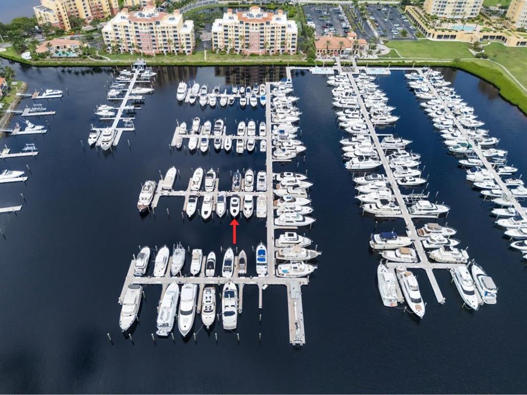 An aerial view of a marina featuring multiple boat slips filled with various watercraft — 102 RIVIERA DUNES WAY UNIT S-46, PALMETTO, FL
