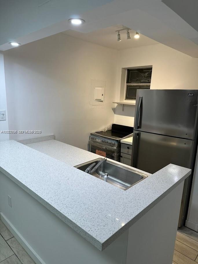 A kitchen features a stainless steel refrigerator, a stove, and a white speckled countertop — 4271 NW 11th St # 1, Miami FL 33126, MIAMI, FL
