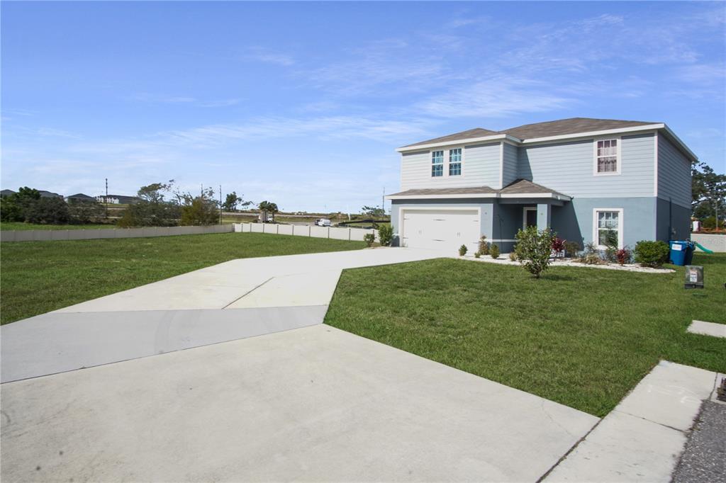 A two-story house with a light blue exterior, a two-car garage, and a concrete driveway — 181 SILVER MAPLE BEND, DAVENPORT, FL
