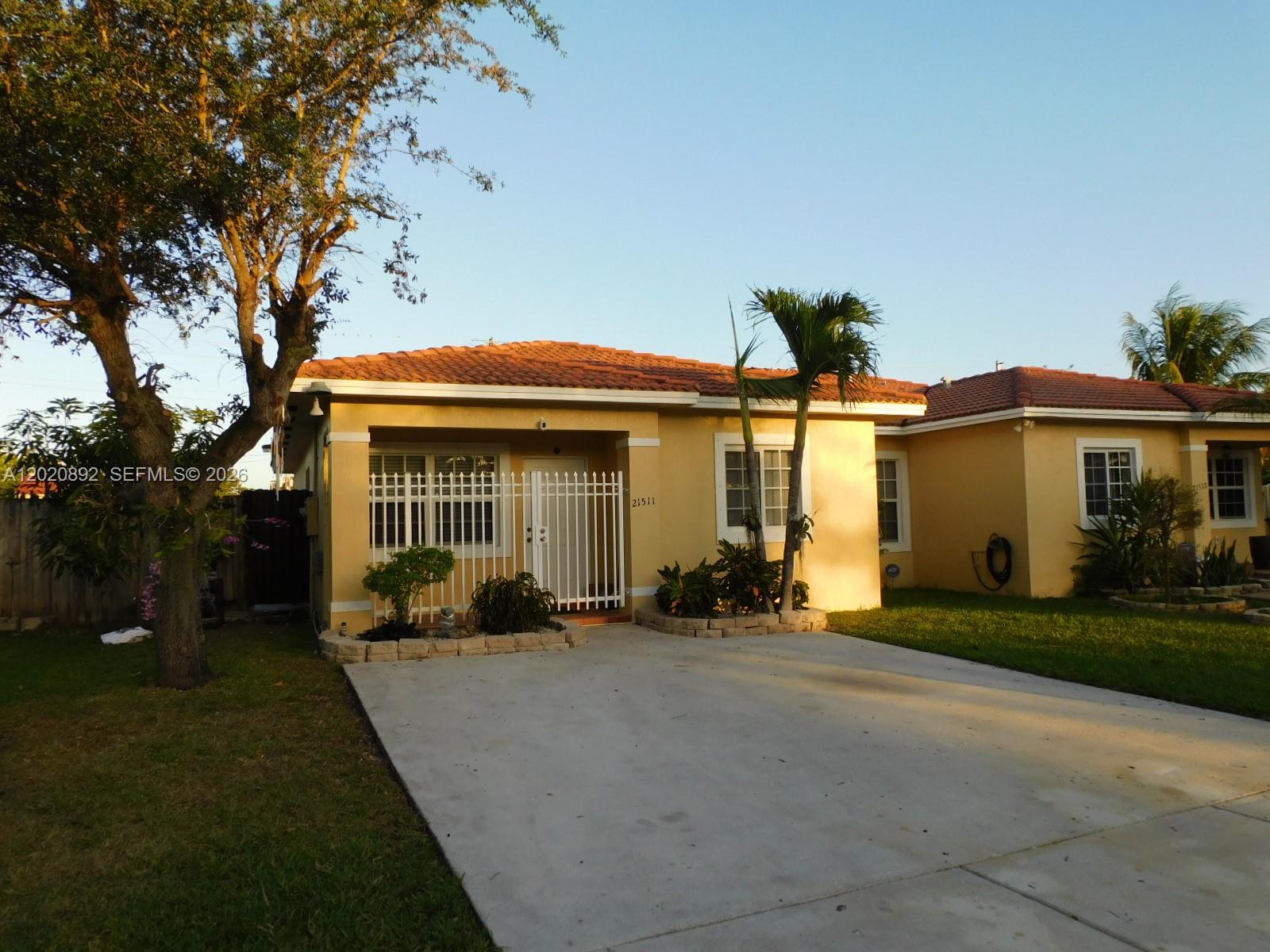 A single-story yellow house with a tiled roof and a concrete driveway — 21511 SW 122nd Ct # 0, Miami FL 33177, MIAMI, FL