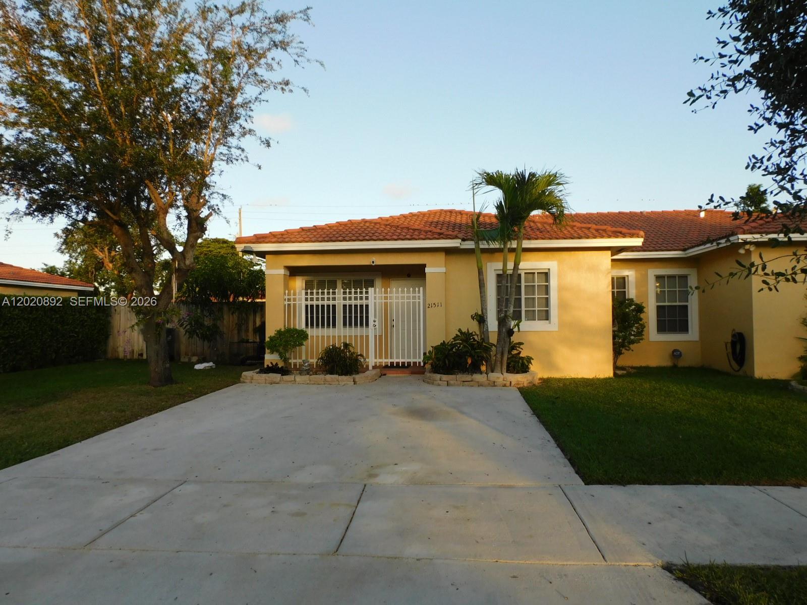 A single-story house with a yellow stucco exterior, tile roof, and a gated front entrance — 21511 SW 122nd Ct # 0, Miami FL 33177, MIAMI, FL