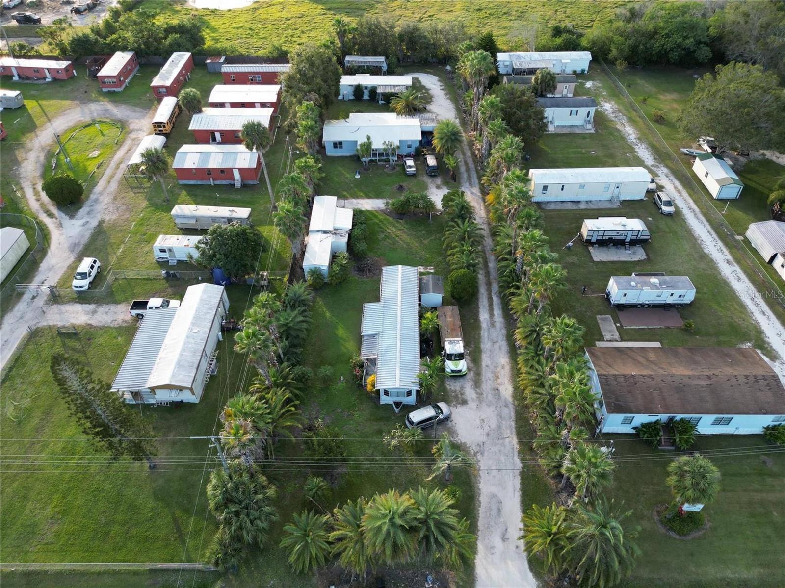 An aerial view shows a mobile home park with multiple dwellings, palm trees, and driveways — 3431 38th Avenue, Okeechobee FL 34974, OKEECHOBEE, FL