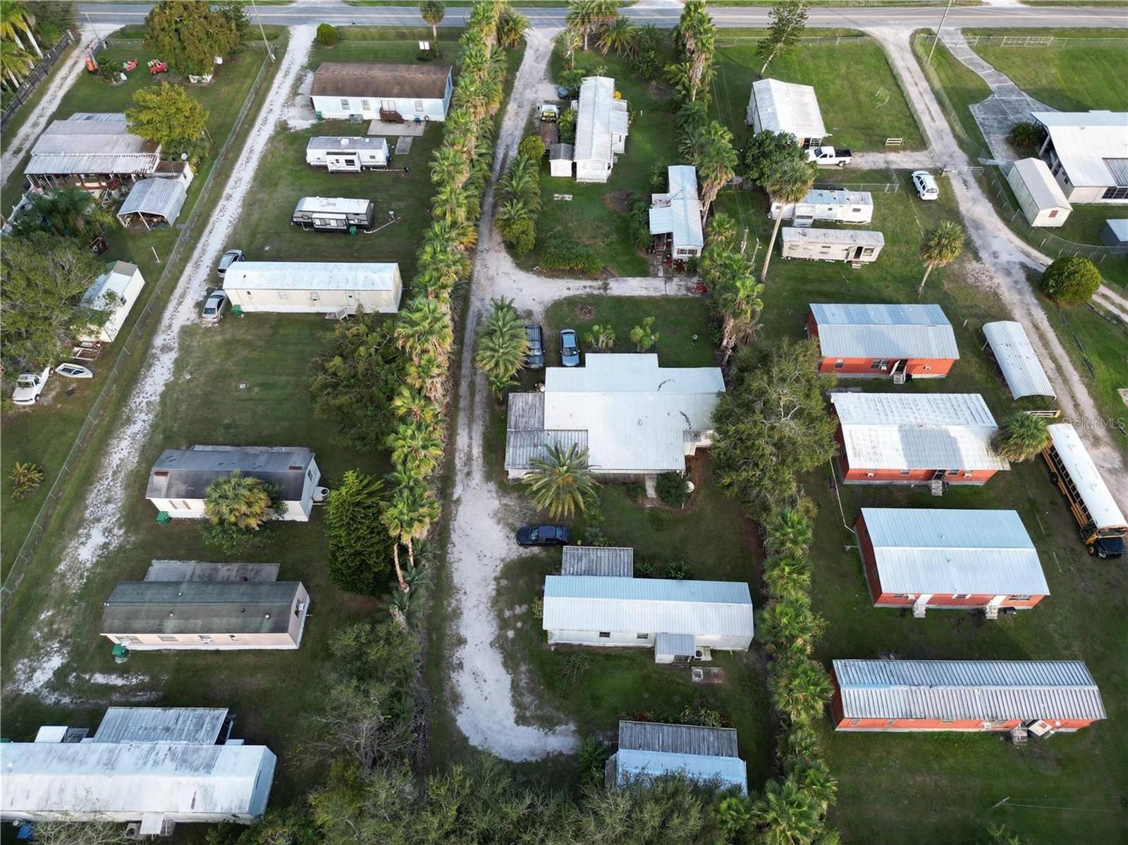 An aerial view shows a residential property with multiple mobile homes and outbuildings on land — 3431 38th Avenue, Okeechobee FL 34974, OKEECHOBEE, FL