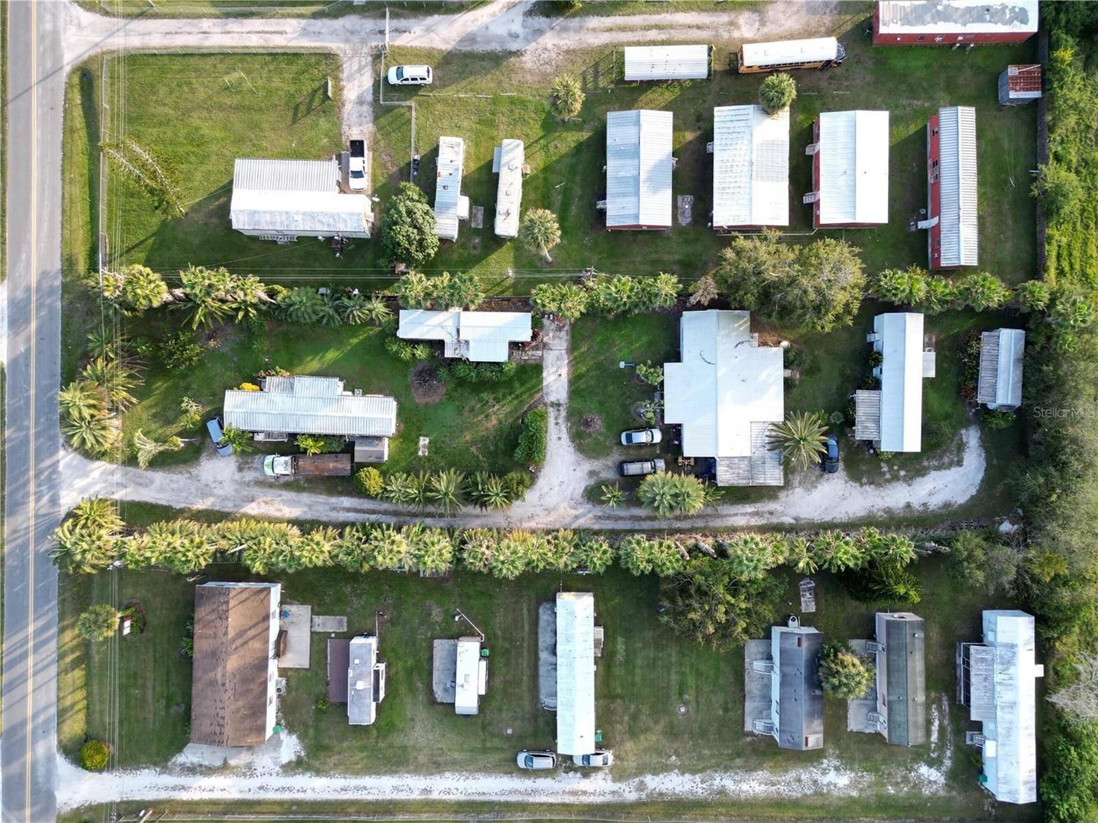 An aerial view shows a mobile home park with multiple dwellings, palm trees, and driveways — 3431 38th Avenue, Okeechobee FL 34974, OKEECHOBEE, FL