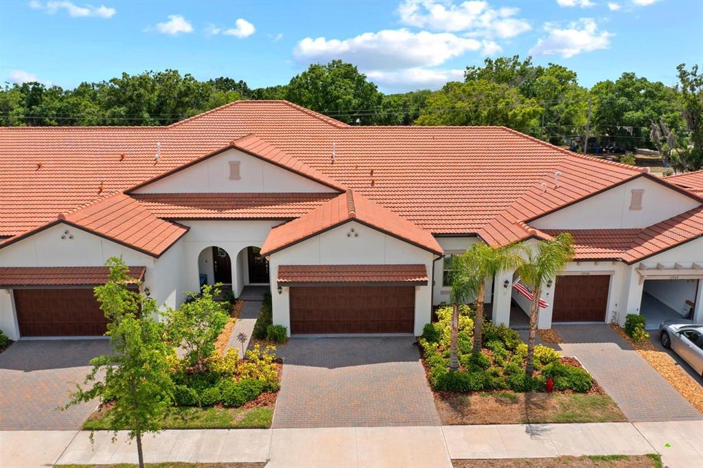An aerial view of a multi-unit residential building with terracotta tile roofs and paved driveways — 17538 HOLLY WELL AVENUE, WIMAUMA, FL