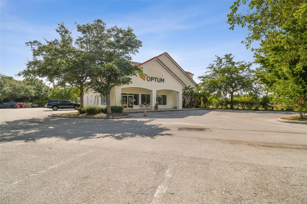 A single-story commercial building with an Optum sign sits in a large paved parking lot — 772 CORTARO DRIVE, SUN CITY CENTER, FL