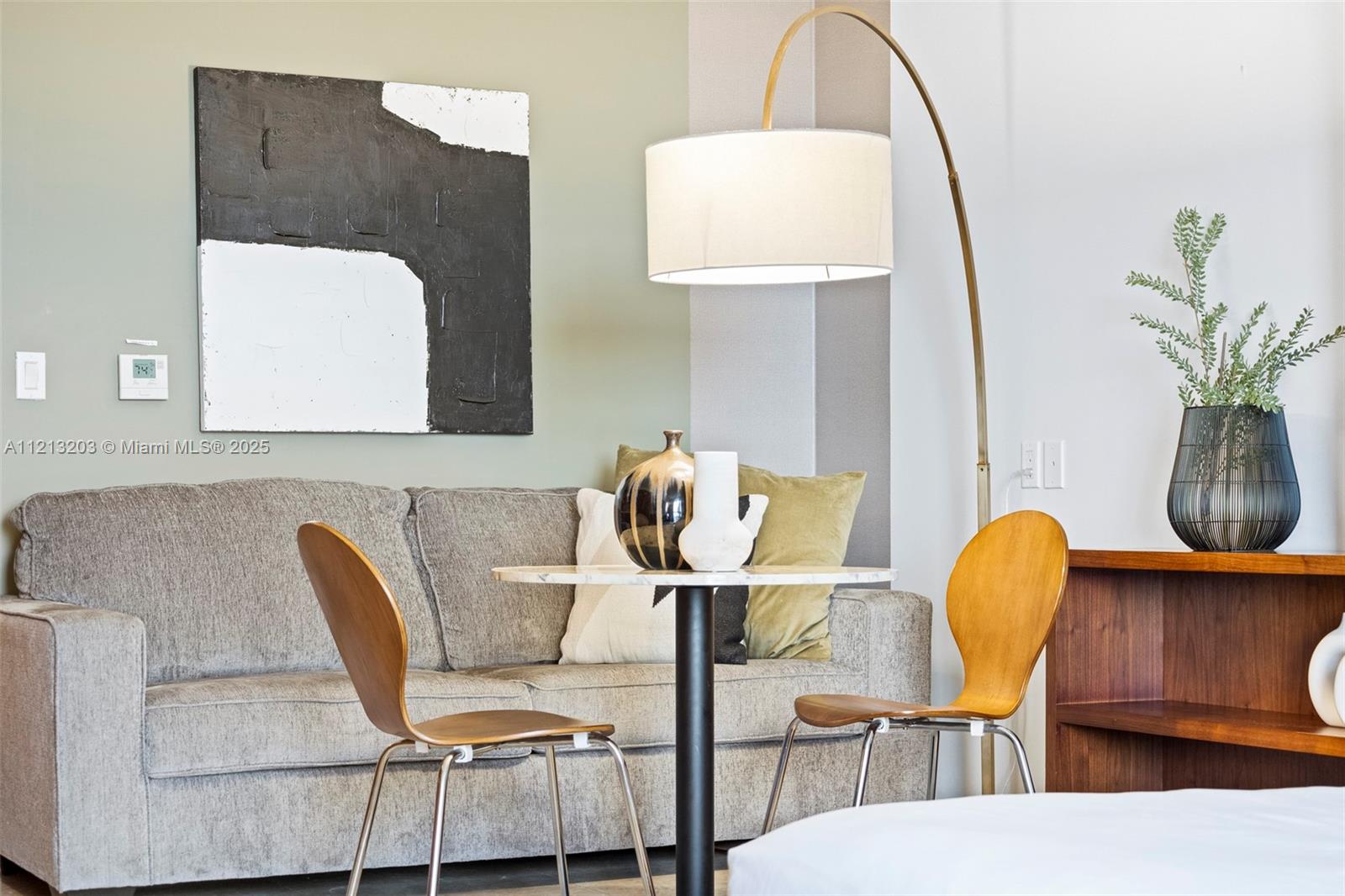 A small dining area features a round table, two wooden chairs, and a gray sofa — 50 Biscayne Blvd # 605, Miami FL 33132, MIAMI, FL