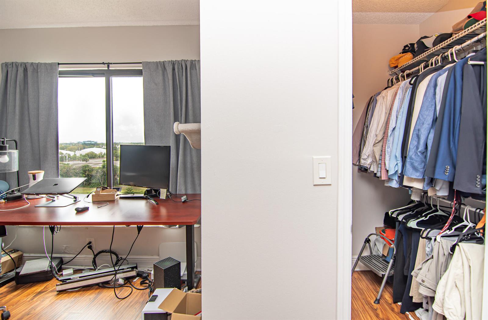 A home office with a desk and window view sits beside an open walk-in closet — 2202 S Cypress Bend Drive # 706, Pompano Beach FL 33069, POMPANO BEACH, FL