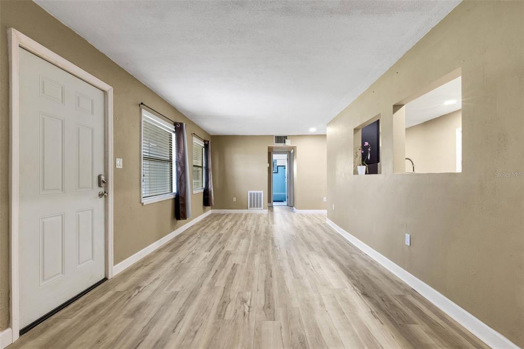 An interior view of a living area featuring light wood-look flooring and tan walls — 3341 CROTON TERRACE, PORT CHARLOTTE, FL