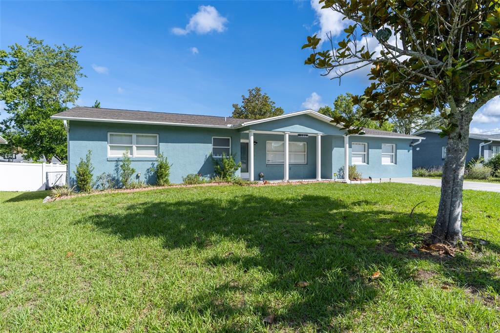A single-story blue house with a covered front porch sits on a grassy lawn — 306 S MONROE STREET, BEVERLY HILLS, FL