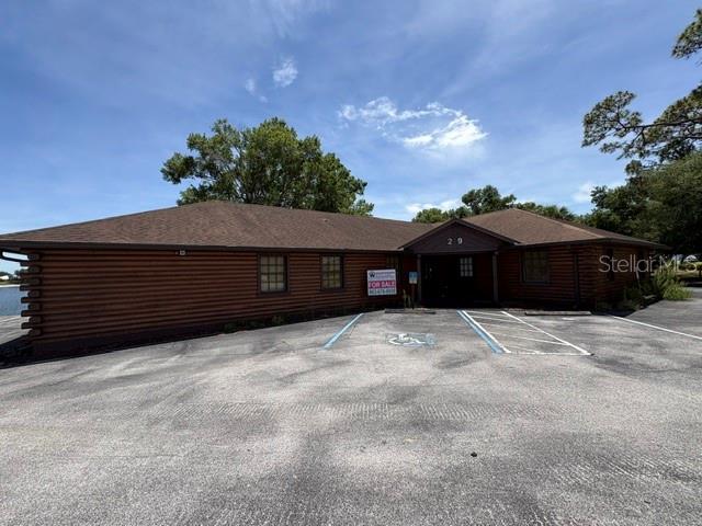 A single-story log cabin style commercial building with a paved parking lot in front — 29 SR-60, LAKE WALES, FL