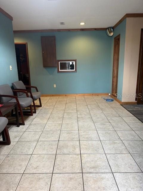 A waiting room features teal walls, tiled flooring, two chairs, and a small wall-mounted cabinet — 29 SR-60, LAKE WALES, FL