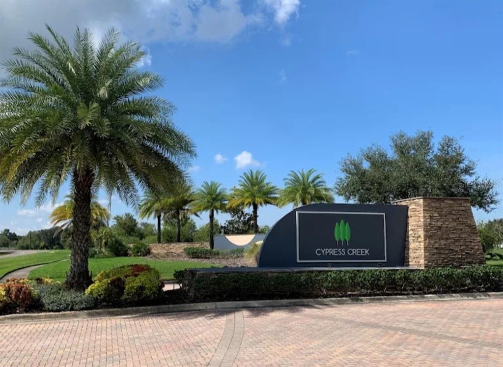 A stone and metal sign for Cypress Creek stands at the entrance of a neighborhood — 6531 TRENT CREEK DRIVE, RUSKIN, FL