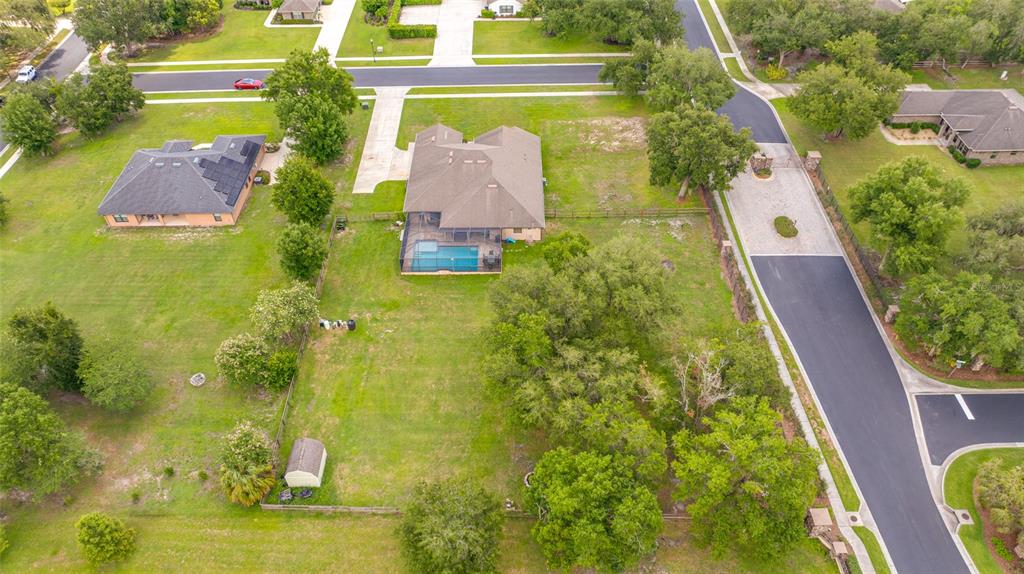 An aerial view shows a house with a pool and a large backyard — 14311 HILL COUNTRY LANE, DADE CITY, FL