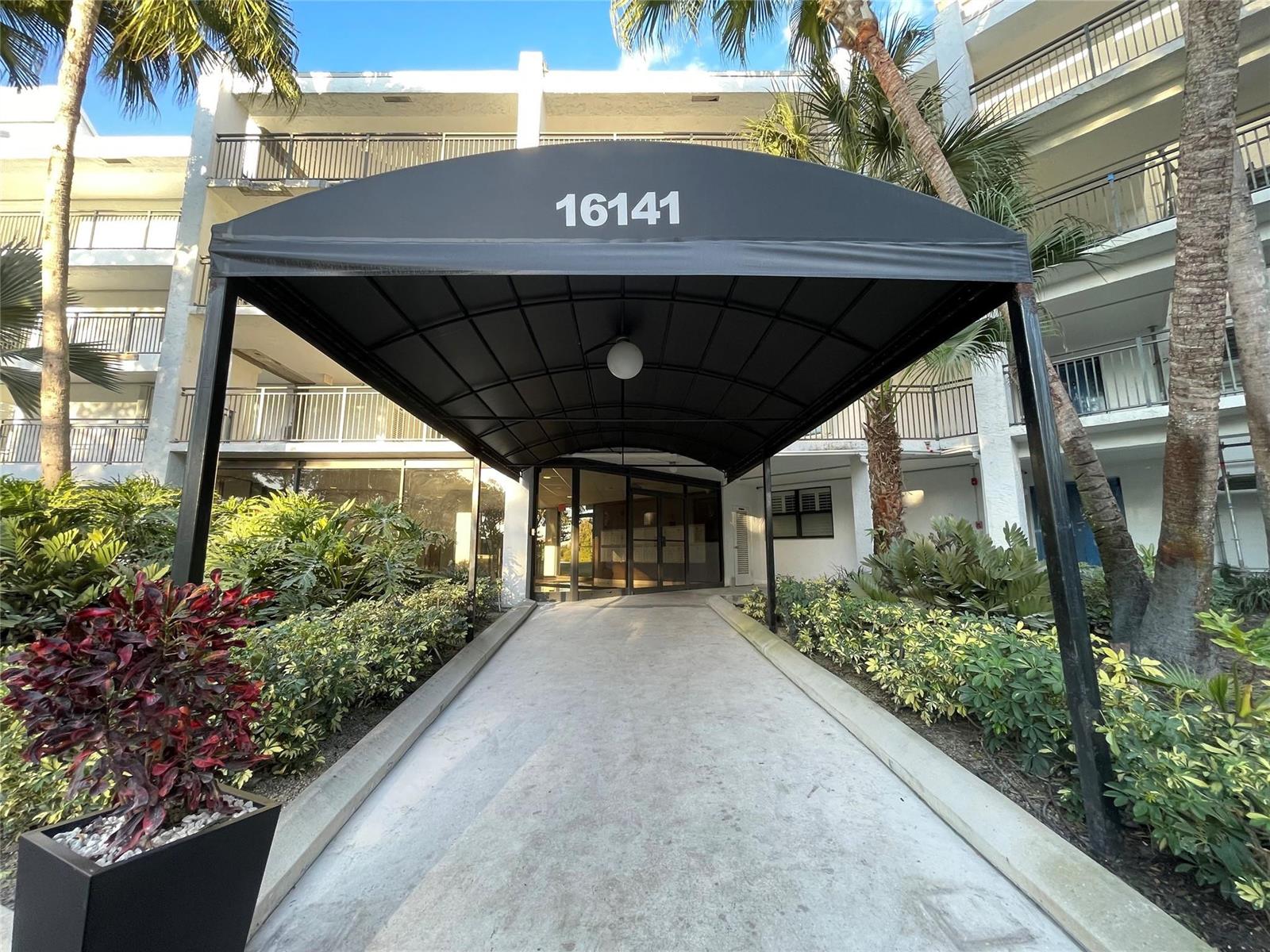 A black awning with the number 16141 covers a concrete walkway leading to a building entrance — 16141 Blatt Boulevard # 408, Weston FL 33326, WESTON, FL