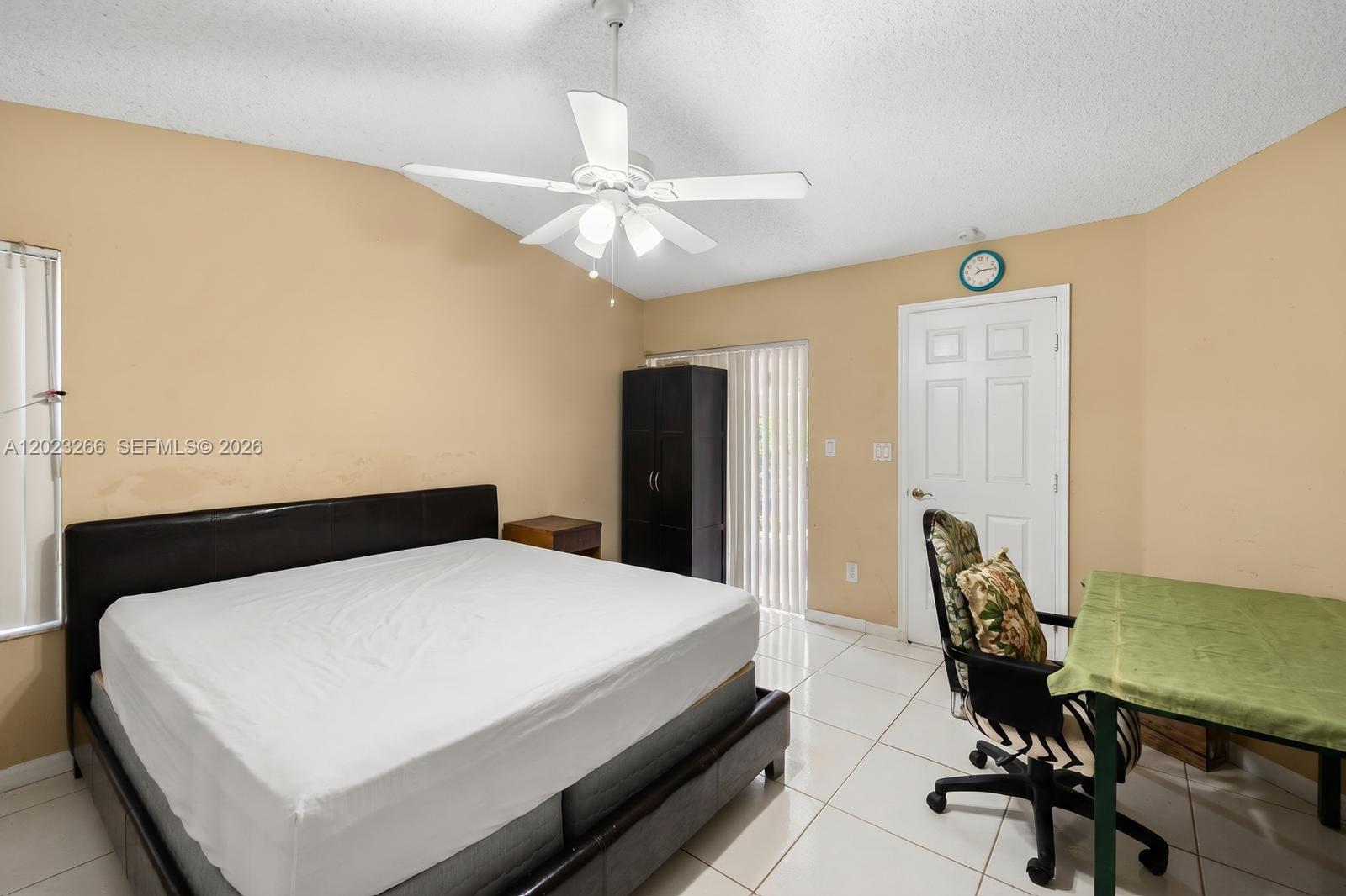 A bedroom features a bed, a desk with a chair, and a ceiling fan — 12360 SW 145th St, Miami FL 33186, MIAMI, FL