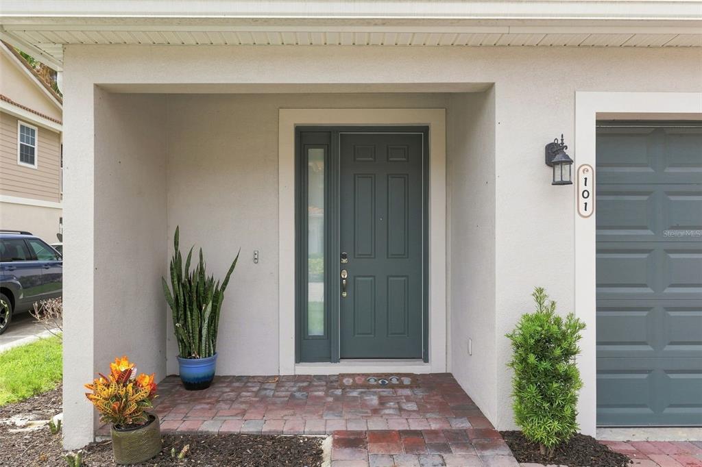 A front entryway features a dark gray door with a sidelight and brick pavers — 1805 NOEL PLACE UNIT 101, MELBOURNE, FL