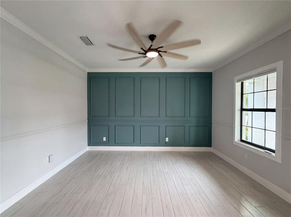 A room with light wood flooring, gray walls, and a teal accent wall with molding — 13176 TWIN BRIDGES DRIVE, RIVERVIEW, FL