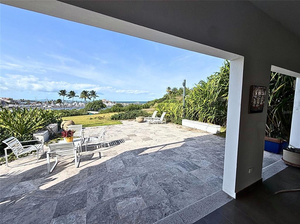 A stone patio overlooks a marina with palm trees and the ocean in the distance — 24.25 HARBORVIEW ROAD, HUMACAO, PR