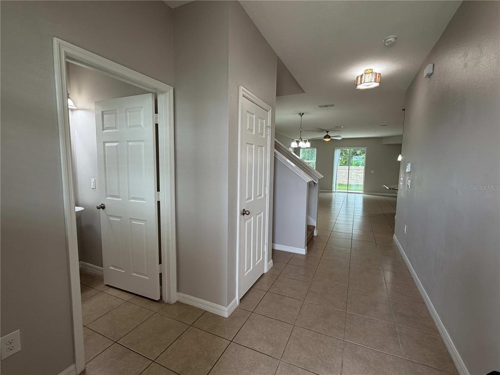 A tiled entryway leads to a hallway with a staircase, a doorway, and a closet — 476 BOTTLEBRUSH LOOP, SANFORD, FL