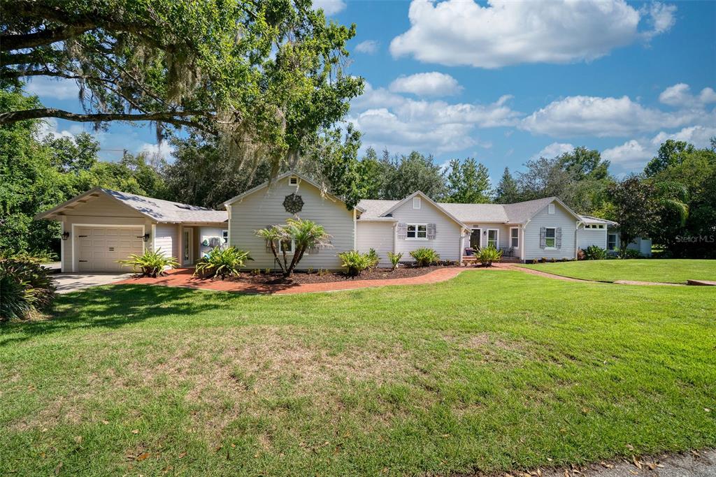 A single-story house with light siding, a garage, and a brick walkway on a lawn — 12085 SANDY SHORES DRIVE UNIT D, WINDERMERE, FL