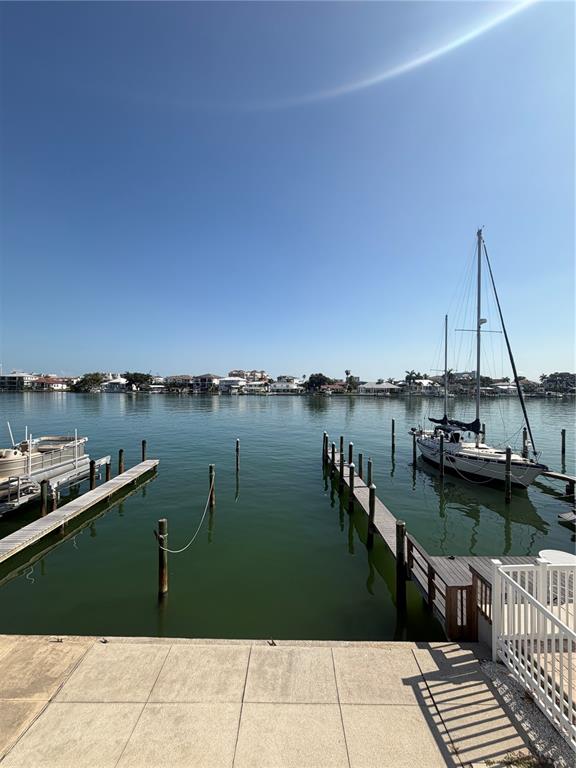 A view of a canal with two boat docks and a sailboat under a clear sky — 716 BAYWAY BOULEVARD UNIT 6, CLEARWATER BEACH, FL