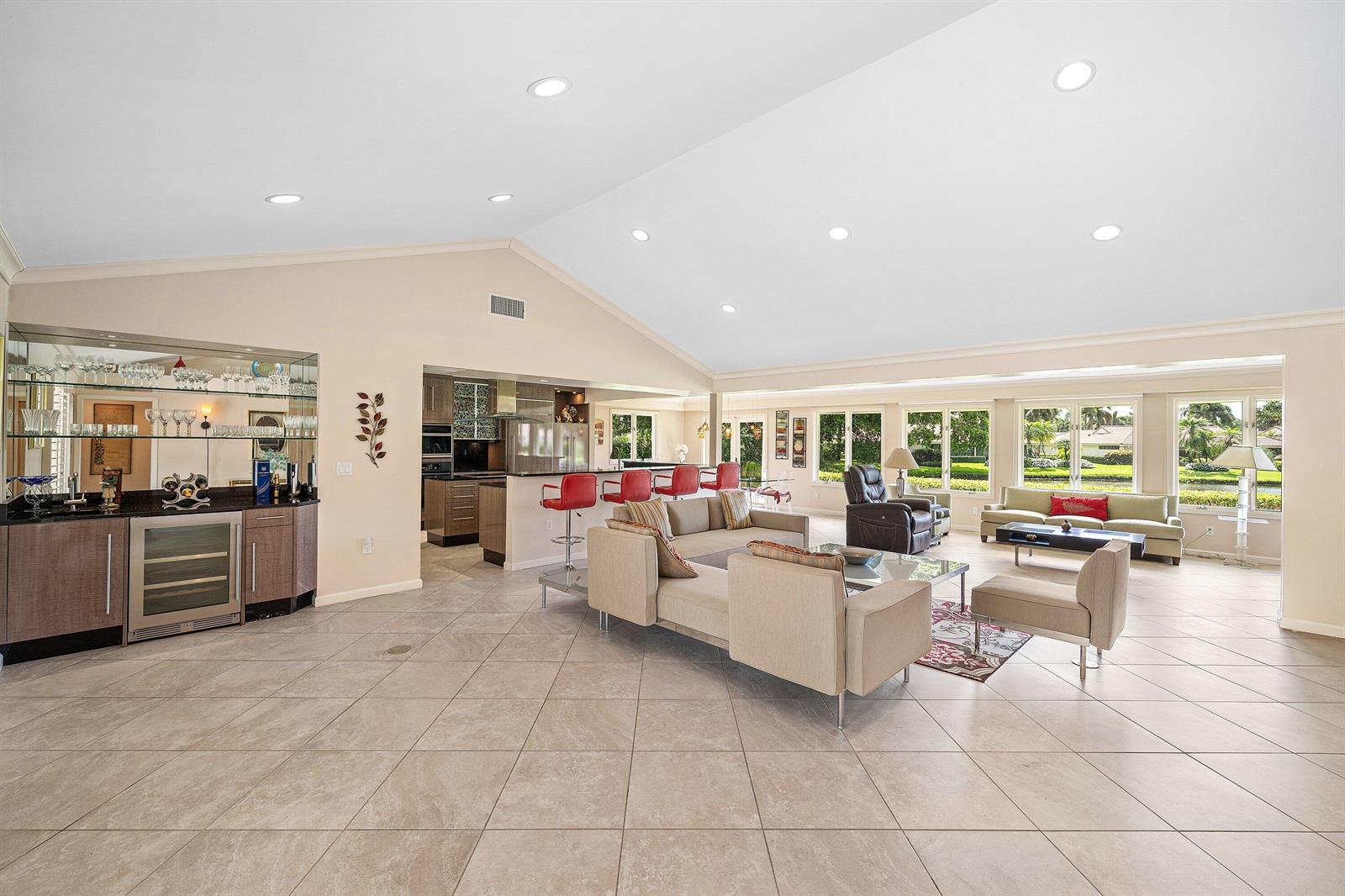 A spacious open-concept living area features a wet bar, kitchen island, and tile flooring — 4365 Shelldrake Lane, Boynton Beach FL 33436, BOYNTON BEACH, FL