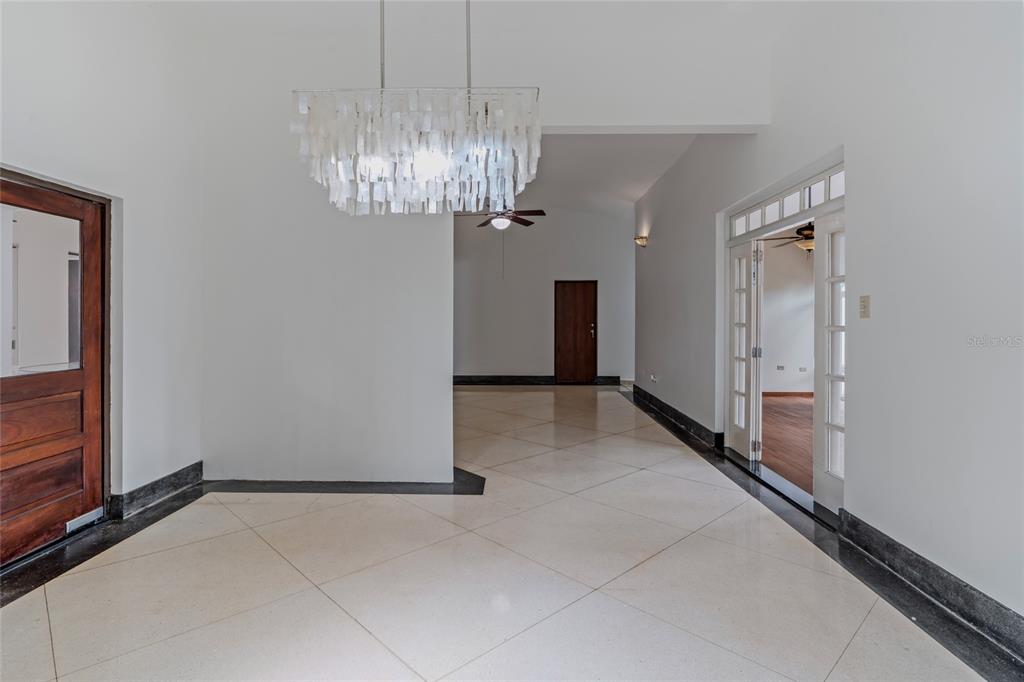 An interior view of a room with white walls, tile flooring, and a decorative chandelier — 30, G St., Villa Caparra G, GUAYNABO, PR